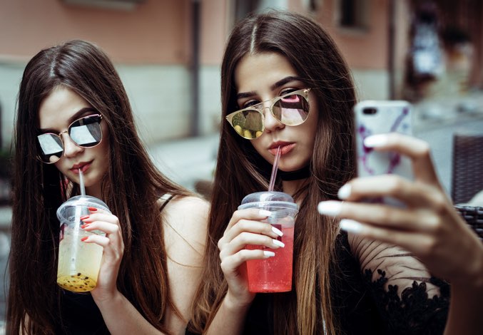 Two girls with sunglasses taking a selfie